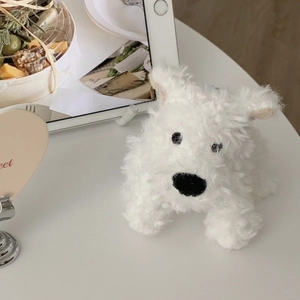 Close-up of a cute white plush Westie dog charm on a cozy lifestyle background