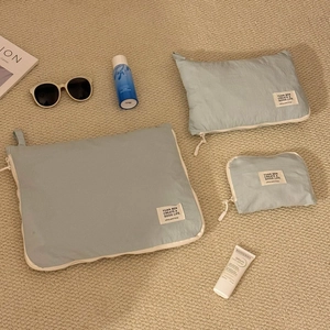 Detail view of mint green waterproof travel storage bags in three sizes on a soft carpet