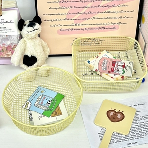 Detail of cream iron mesh storage baskets in round and rectangular shapes for desk organization