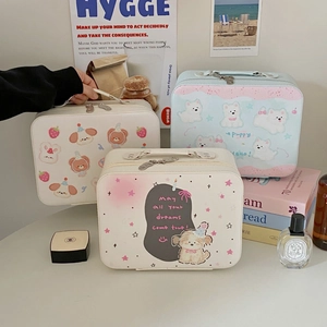 Detail van draagbare cartoon cosmetische koffers met puppy- en berenprints op tafel