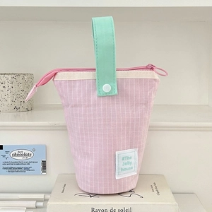 Detail of pink striped fabric pencil case with mint green handle and snap button