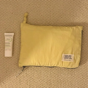 Detail view of yellow waterproof nylon travel storage bag with zipper and carry handle