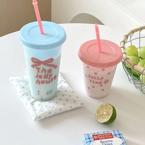 Close-up van schattige plastic drinkbekers met grote capaciteit, strikjes en rietjes