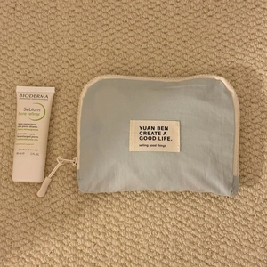Close-up of a light blue waterproof travel organizer bag with zipper and logo patch