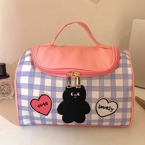 Vue détaillée d'une trousse à maquillage violette à carreaux avec patchs cœur et ours
