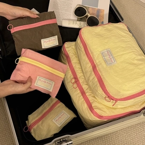 Multi-size colorful travel organizer bags set in suitcase with retro woven label