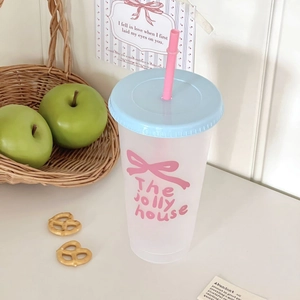 Detail van matte plastic beker met blauw deksel, roze rietje en roze strikprint