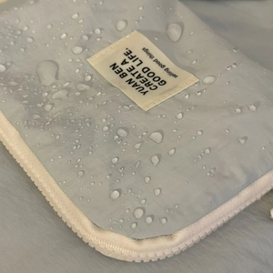 Close-up of waterproof light blue travel organizer bag with visible water droplets detail