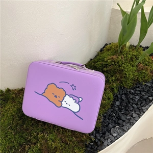 Detail of purple cartoon vanity case featuring a teddy bear illustration and top handle