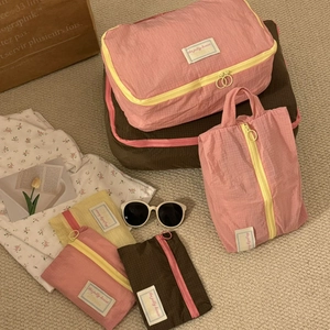 Detailed set of colorful waterproof travel organizer bags on a soft woven rug