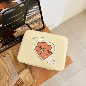 Close-up of cream PU leather cosmetic bag featuring a cute brown cartoon bear and heart