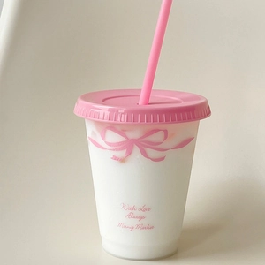 Detail van schattige plastic beker met roze strik en herbruikbaar rietje voor drinken