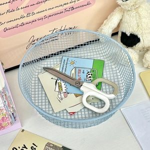 Top view of a light blue round wire mesh basket holding vintage cards and scissors