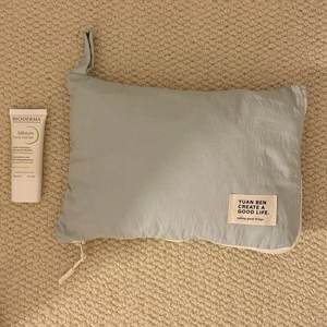 Detail of light blue waterproof travel organizer bag with zipper and logo label