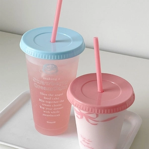 Detailweergave van twee pastel herbruikbare plastic bekers met rietjes in blauw en roze