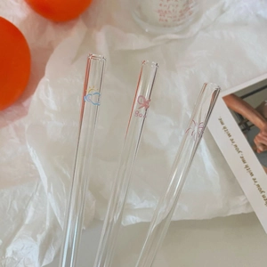 Close-up of heat-resistant glass straws with cute cartoon butterfly and sun patterns