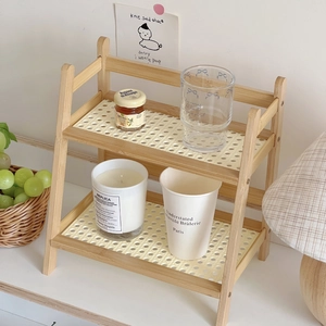 Close-up of a 2-tier cream rattan shelf showing natural wood frame and woven textures