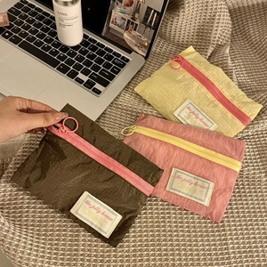 Close-up of nylon grid travel organizer bags with circular zipper pulls in three colors
