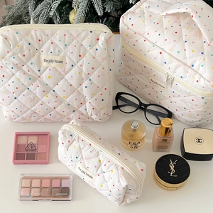 Three-piece quilted makeup bag set featuring colorful polka dots and cream finish