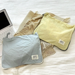 Detail of minimalist waterproof travel organizers in pastel blue and yellow with top zipper