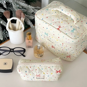 Detailed view of quilted makeup bags with colorful polka dots and bow patterns