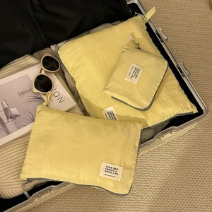 Detail of yellow waterproof travel organizers with zipper closure inside a suitcase