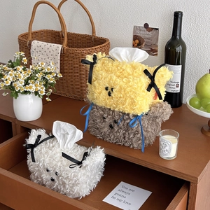 Three plush teddy-style tissue box covers with cute bow ties in home setting decoration