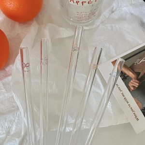 Close-up of five clear glass straws with delicate hand-painted butterfly and floral patterns