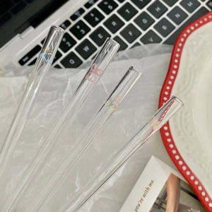 Set of four clear heat-resistant glass straws with cute cartoon flower and heart patterns