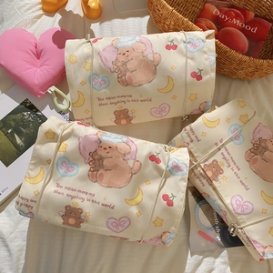 Macro view of creamy satin toiletry bags featuring cute cartoon bear and moon patterns