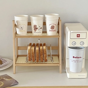 Close-up of double-layer wooden organizer rack with silver toast holder and cream cups