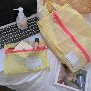 Close-up of yellow checkered travel organizers with pink zippers and retro fabric labels
