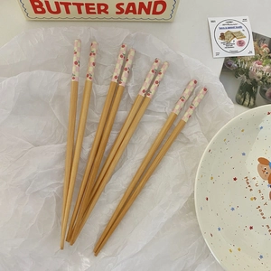 Detail of four bamboo chopsticks featuring cherry patterns and pastel checkered tips