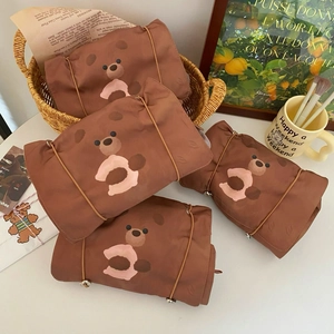 Detail of 4-in-1 brown toiletry bags with bear prints and elastic fastening straps