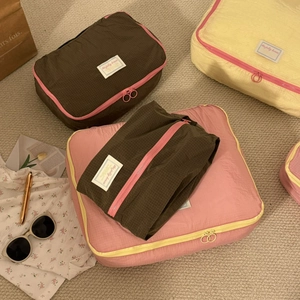 Detail of travel packing cubes with circular pull zippers and contrasting trim details
