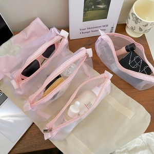 Foldable 4-in-1 pink mesh toiletry bag for makeup and travel essentials on a desk
