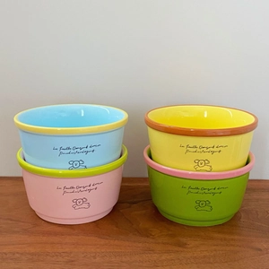Detail of four ceramic dog bowls featuring hand-drawn illustrations and French poetry
