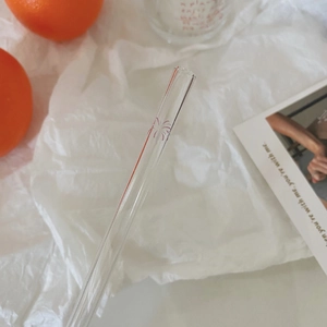 Close-up of heat-resistant glass straw featuring a delicate purple floral pattern detail