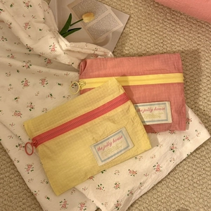 Detail of plaid travel organizers with zippers in yellow and pink pastel shades