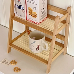 Close-up of two-tier cream rattan desktop shelf with a natural bamboo frame