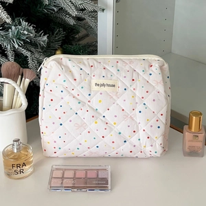 Detailed view of quilted cotton makeup bag with colorful polka dots and a top zipper