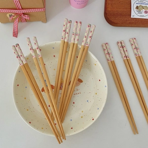 Detail of bamboo chopsticks with pink checkerboard print and ceramic tray set