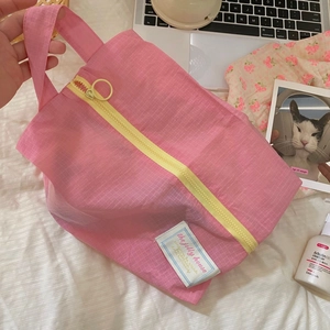 Detail of pink plaid travel organizer bag with yellow zipper and metal ring handle
