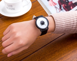 Close-up of stylish unisex quartz watch with unique rotating dial in a cozy lifestyle setting