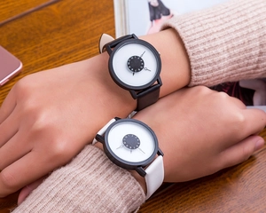 Close-up of minimalist couple watches featuring creative rotating hour disc and leather strap
