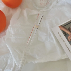 Detail of eco-friendly glass straw featuring delicate yellow and purple butterfly prints