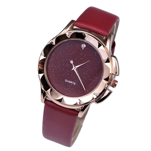 Dettaglio della lunetta a petalo oro rosa e quadrante stellato bordeaux dell'orologio