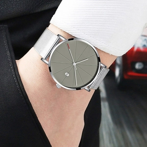 Close-up of minimalist silver quartz watch with grey dial and Milanese mesh strap on wrist
