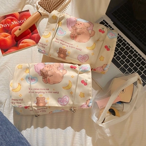 Detail of detachable bear toiletry bags and mesh pouches on white fabric background