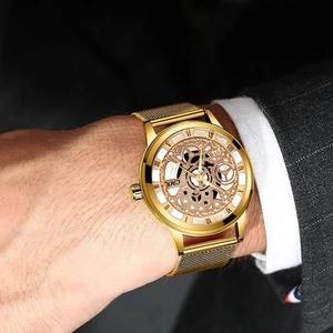 Golden CMK business watch with hollow skeleton dial and mesh metal strap on wrist